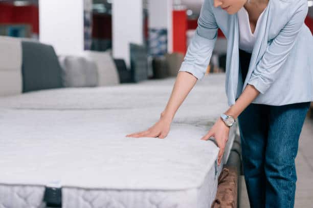 how much does a new mattress cost? woman shopping for a mattress - custom sleep technology